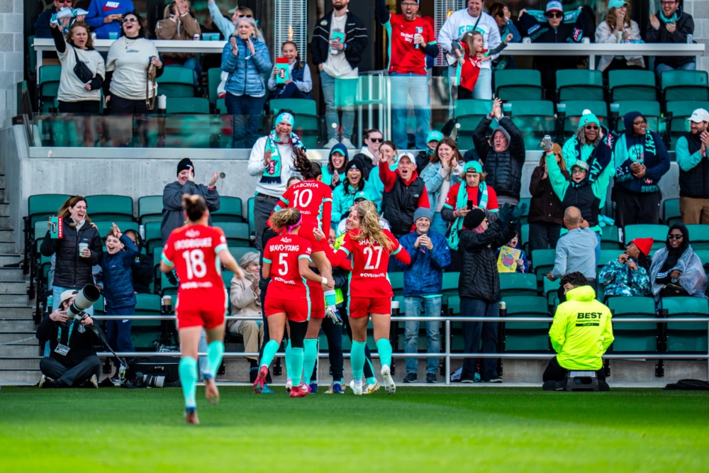 Lo’eau LaBonta, Ellie Bravo-Young, and Kayla Sharples celebrating in front of fans