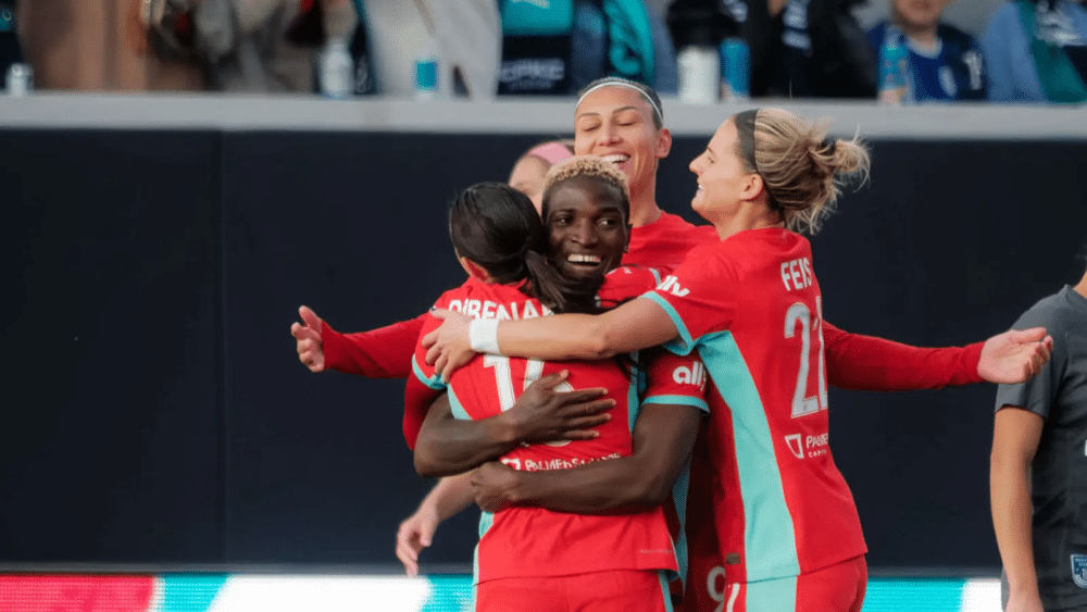 DiBernardo, Bia, Chawinga, and Feist are celebrating a goal.