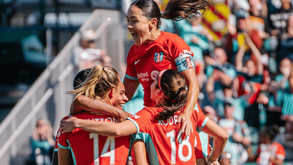 Claire, Izzy, Cooper, and Lo are celebrating a goal.