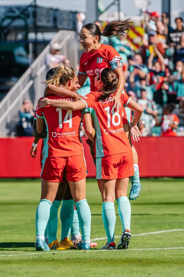 Claire, Izzy, Cooper, and Lo are celebrating a goal.